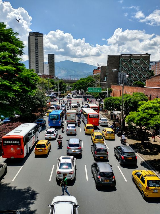 Tráfico urbano en calle colombiana con edificios altos